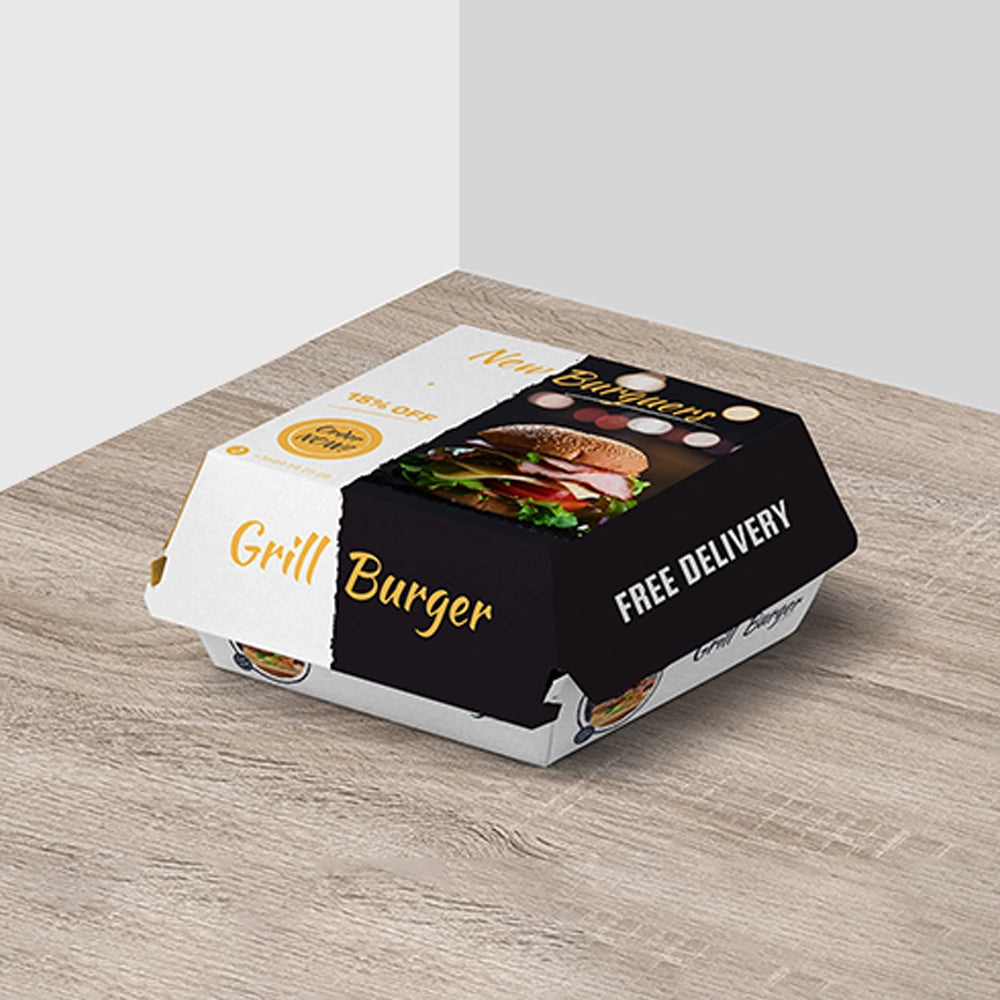 Black and white grill burger box with a photo of a cheeseburger and ‘free delivery’ text, placed on a wooden table.