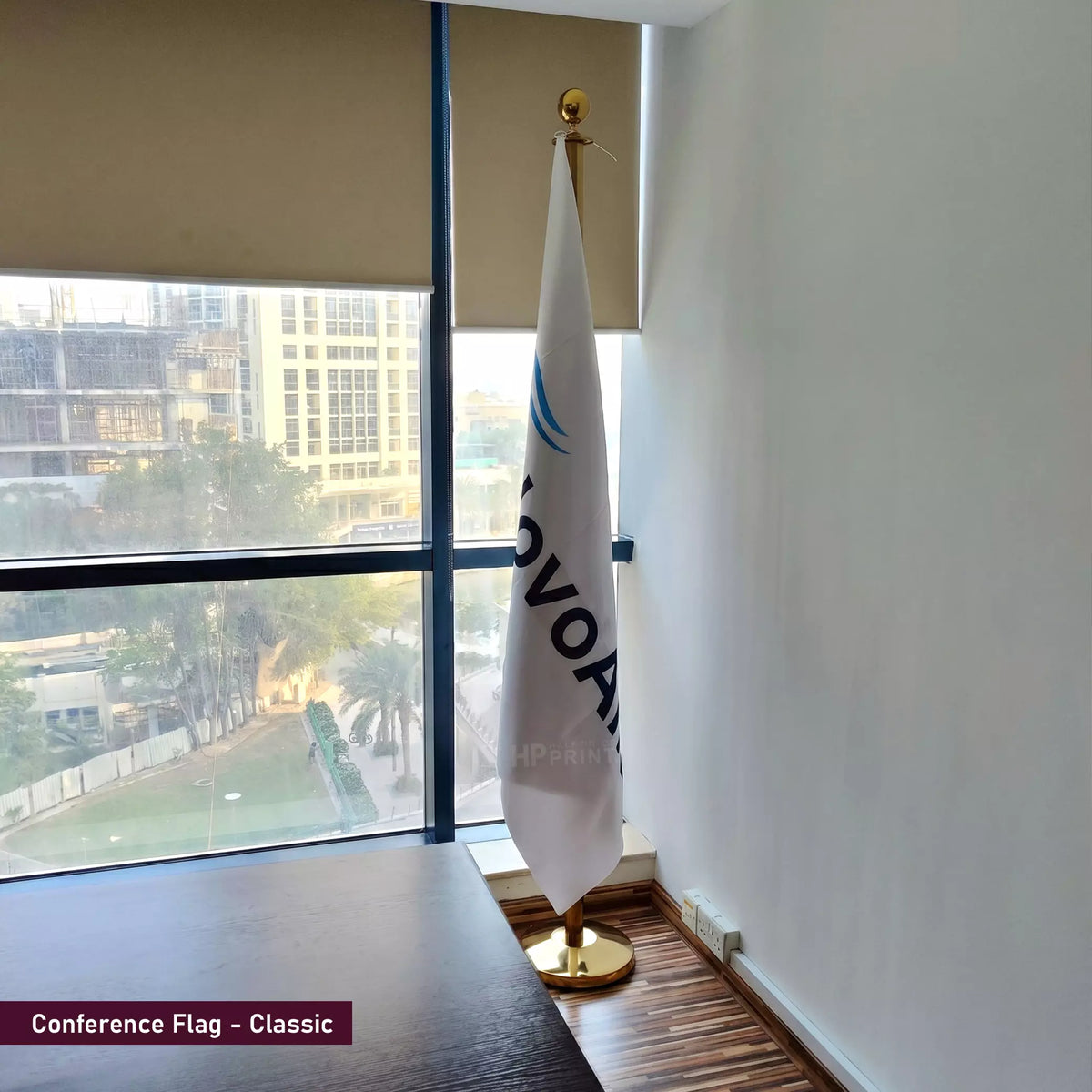 Flag with 'OVOP' branding in a room with large windows showing an outdoor view.