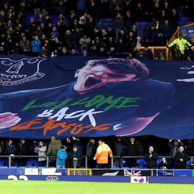 A large custom stadium flag displayed at a sporting event with a graphic and text that reads 'WELCOME BACK EFCUS' on a dark background.
