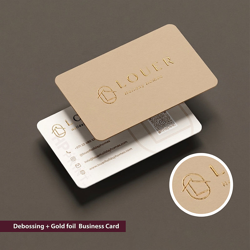 Debossed gold foil business card with Louer branding on a dark background