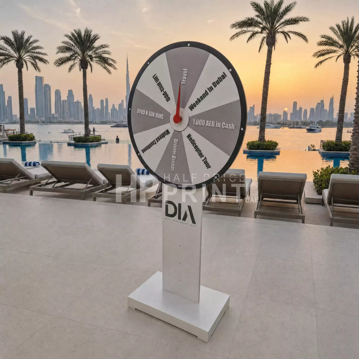 Spin wheel with promotional text on a stand by a pool with palm trees and city skyline in the background