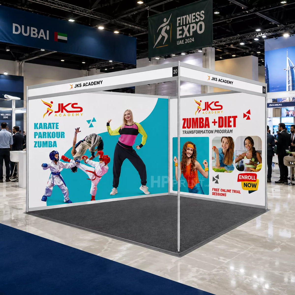 A JKS Academy exhibition booth at a fitness expo, featuring large printed panels with images of people doing karate and zumba, set in a trade show hall.