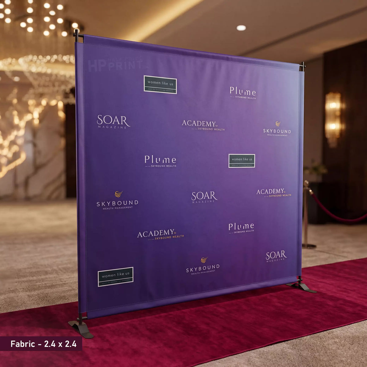 Purple event step and repeat backdrop with logos on a red carpet in an indoor setting