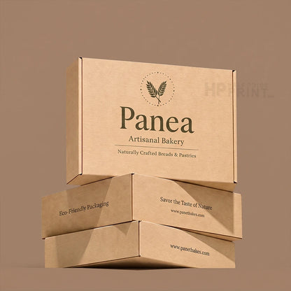 Three stacked kraft paper bakery boxes with printed branding for Panea Artisanal Bakery on a warm taupe background.