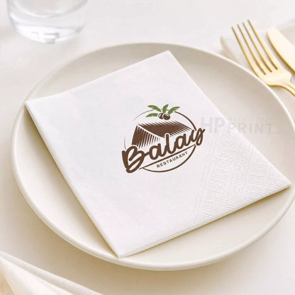 Napkin with Balau Restaurant logo on a white plate with cutlery