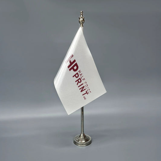 A white table flag with red text, mounted on a metal stand.