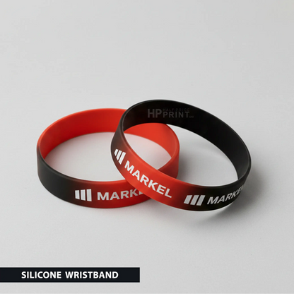 Two silicone wristbands, one red and one black, with 'MARKEL' branding on a gray background.